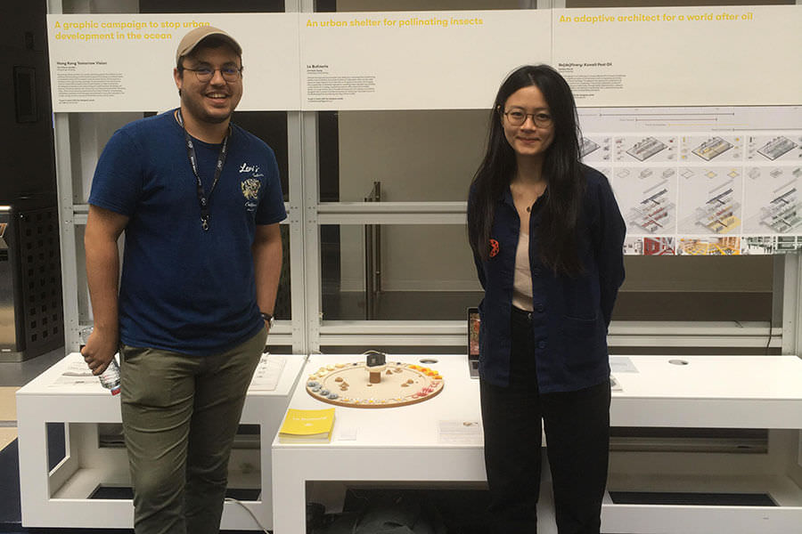 Christelle Zheng et un de ses collaborateurs devant leur stand d'exposition au Global Grad Show école de design ; Global Grad Show